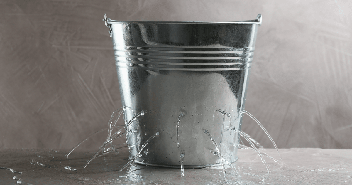 Un balde metálico con múltiples fugas de agua: una metáfora del churn